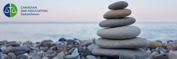 CBA-SK logo and stacked rocks on a shore